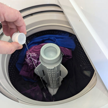 A capful of Gear Guard is added to a load of washing.