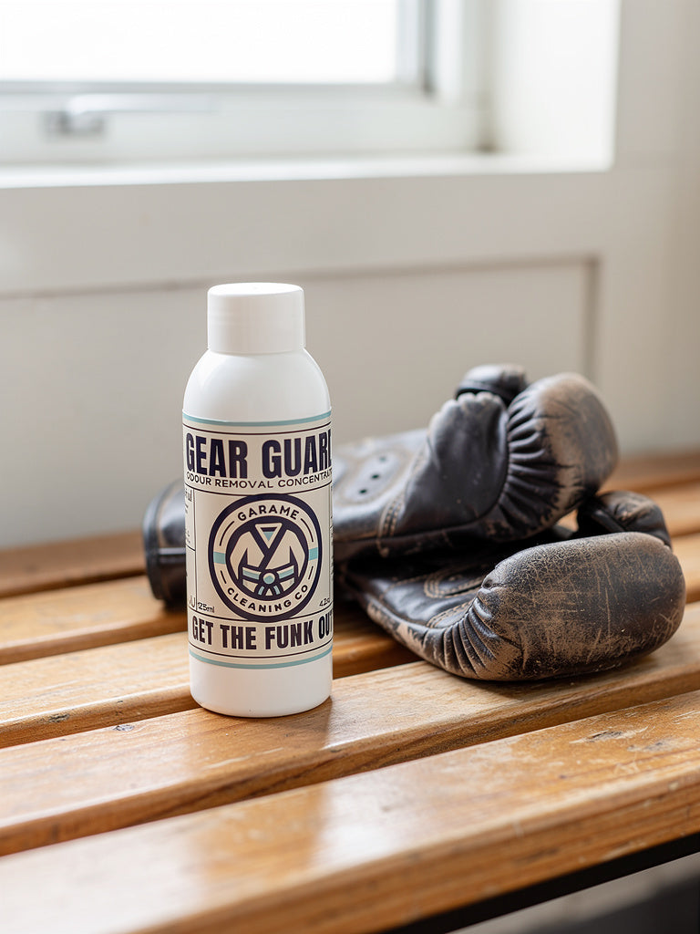 Gear Guard bottle with a pair of old boxing gloves on a wooden bench.