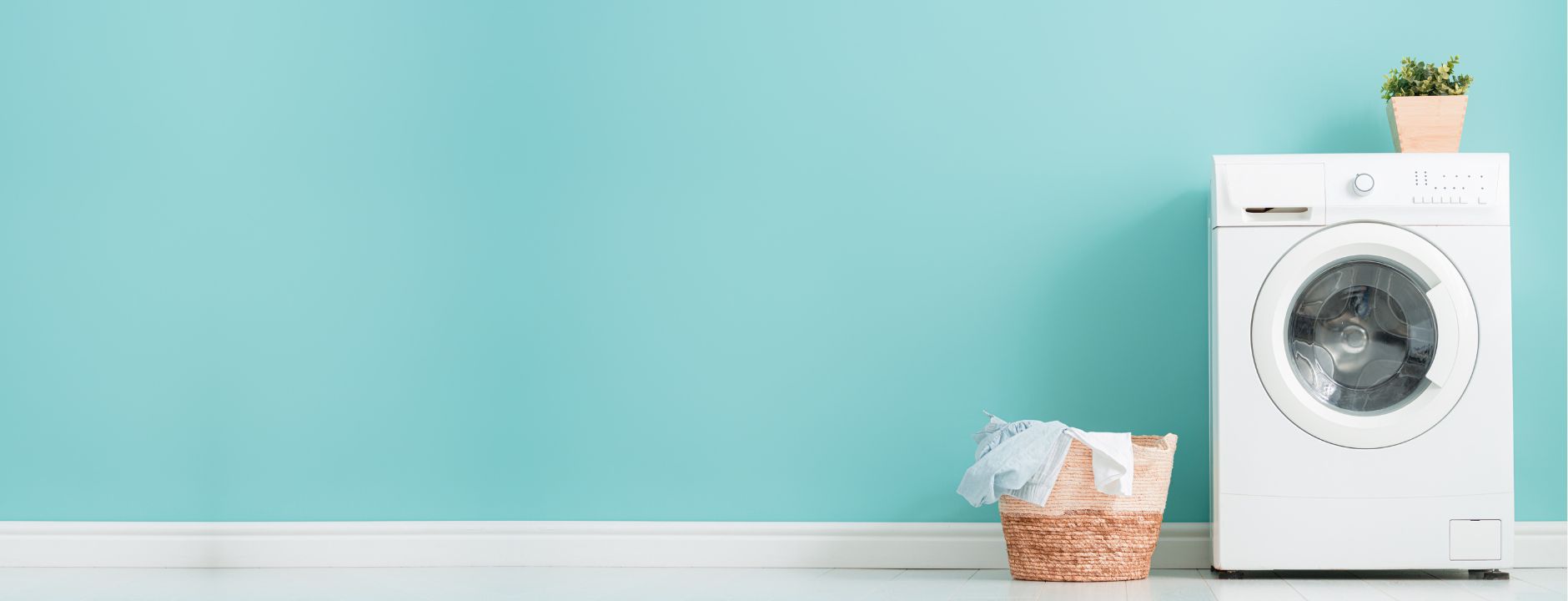 Front load washing machine and laundry basket against a teal wall – a clean, fresh laundry.